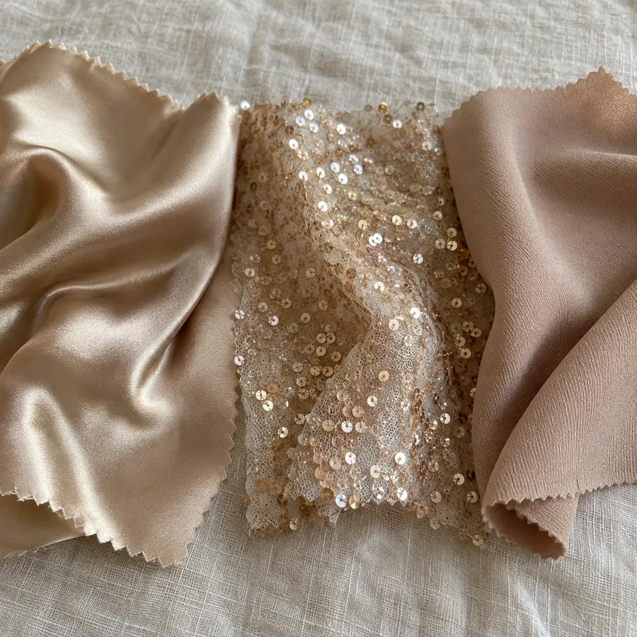 Three fabric swatches on linen: satin, sequin mesh and crepe